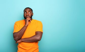 Confuse and pensive expression of a black boy. cyan colored background